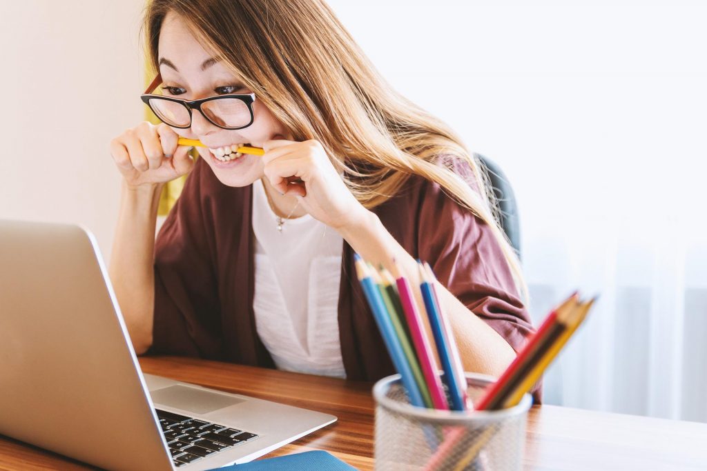 a woman biting a pencil