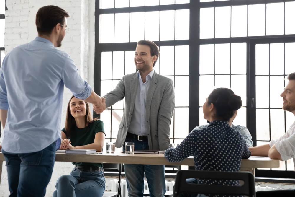 Congratulate you on promotion! Male leader ceo boss handshaking with happy young man worker greeting with financial reward, salary or career growth,